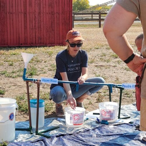 Heritage Interpreter demonstrates a changing river using a PVC model.