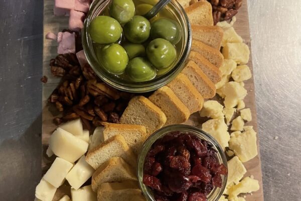 Charcuterie board with meats, cheeses, olives, berries, and crackers at Jessup Farm Barrel House.